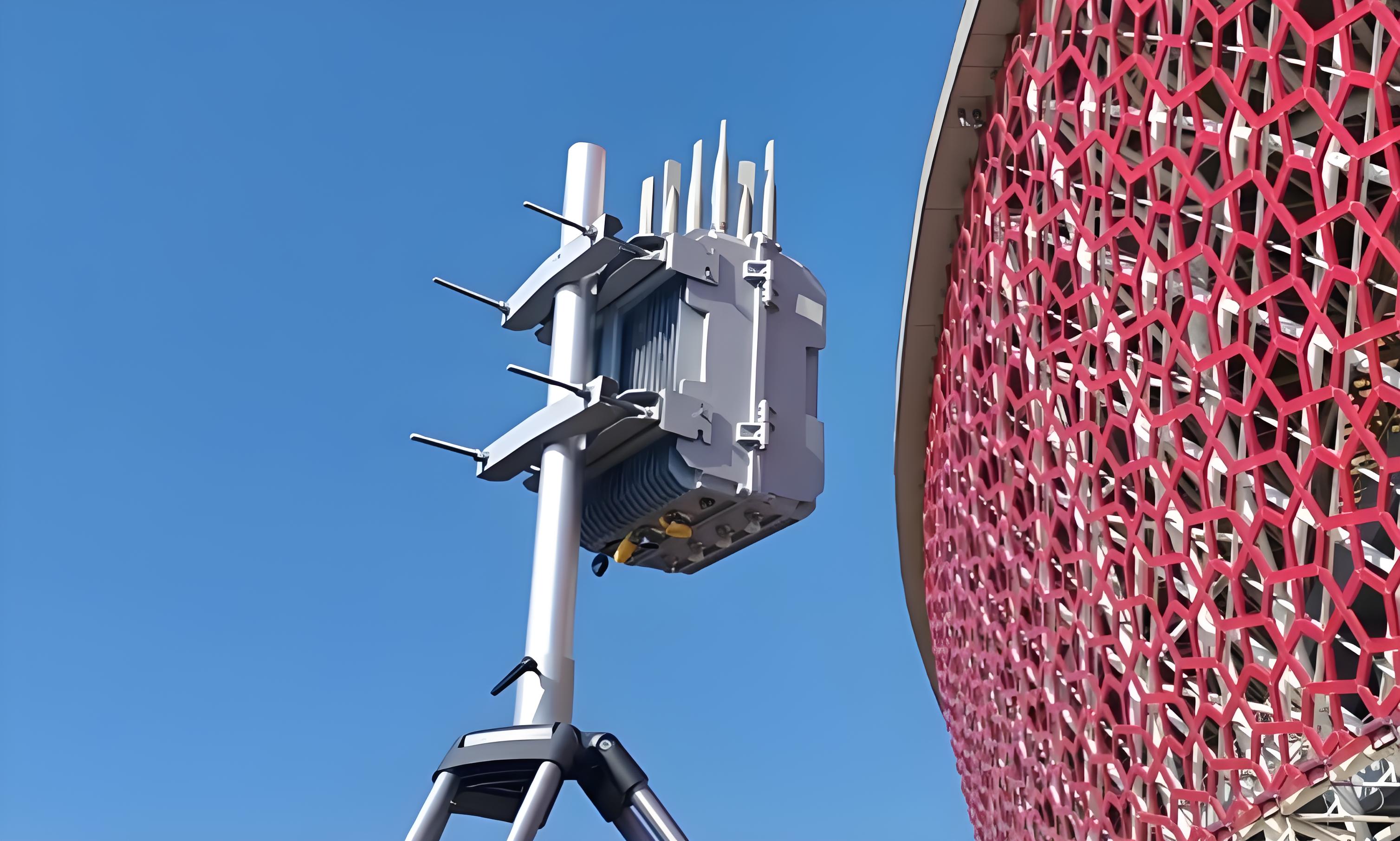 Anti - drone equipment on a pole near a building with red lattice facade