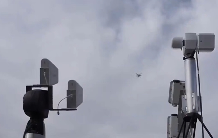 Equipo de interferencia de drones interceptando UAV en campo abierto bajo cielo nublado